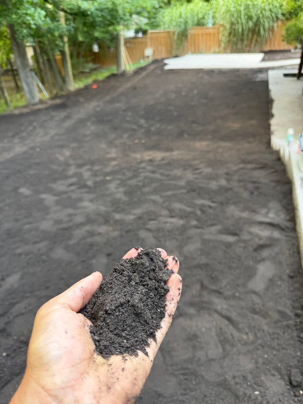 Sod Installation On Carrington Place, Waterloo 10 A handful of the dark topsoil graded across the back yard at the Carrington Place, Waterloo job