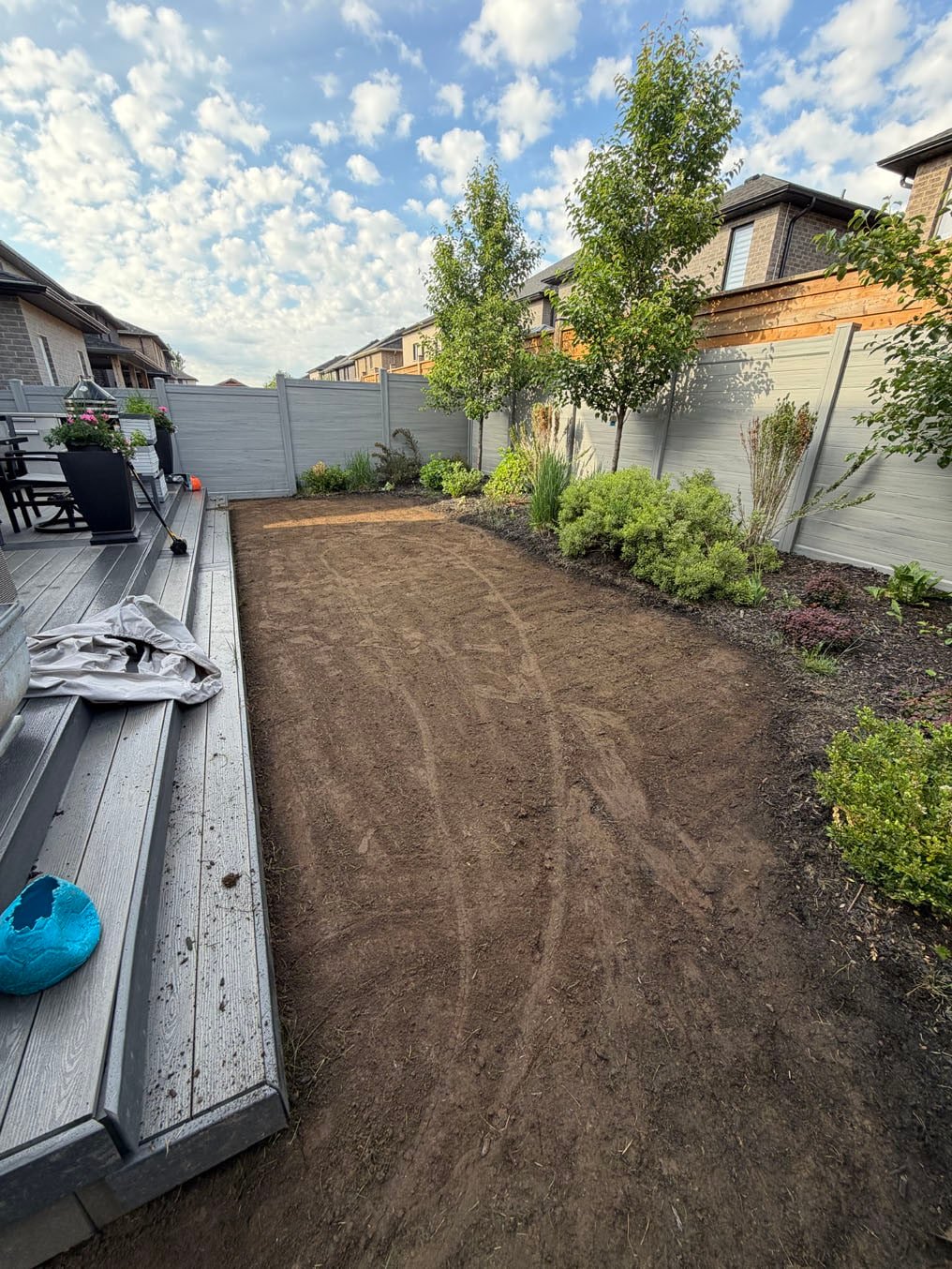 Sod Installation In Doon South, Kitchener 9 Backyard in Doon South, Kitchener stripped to bare soil from the deck steps to the shrub border, ready for fresh topsoil