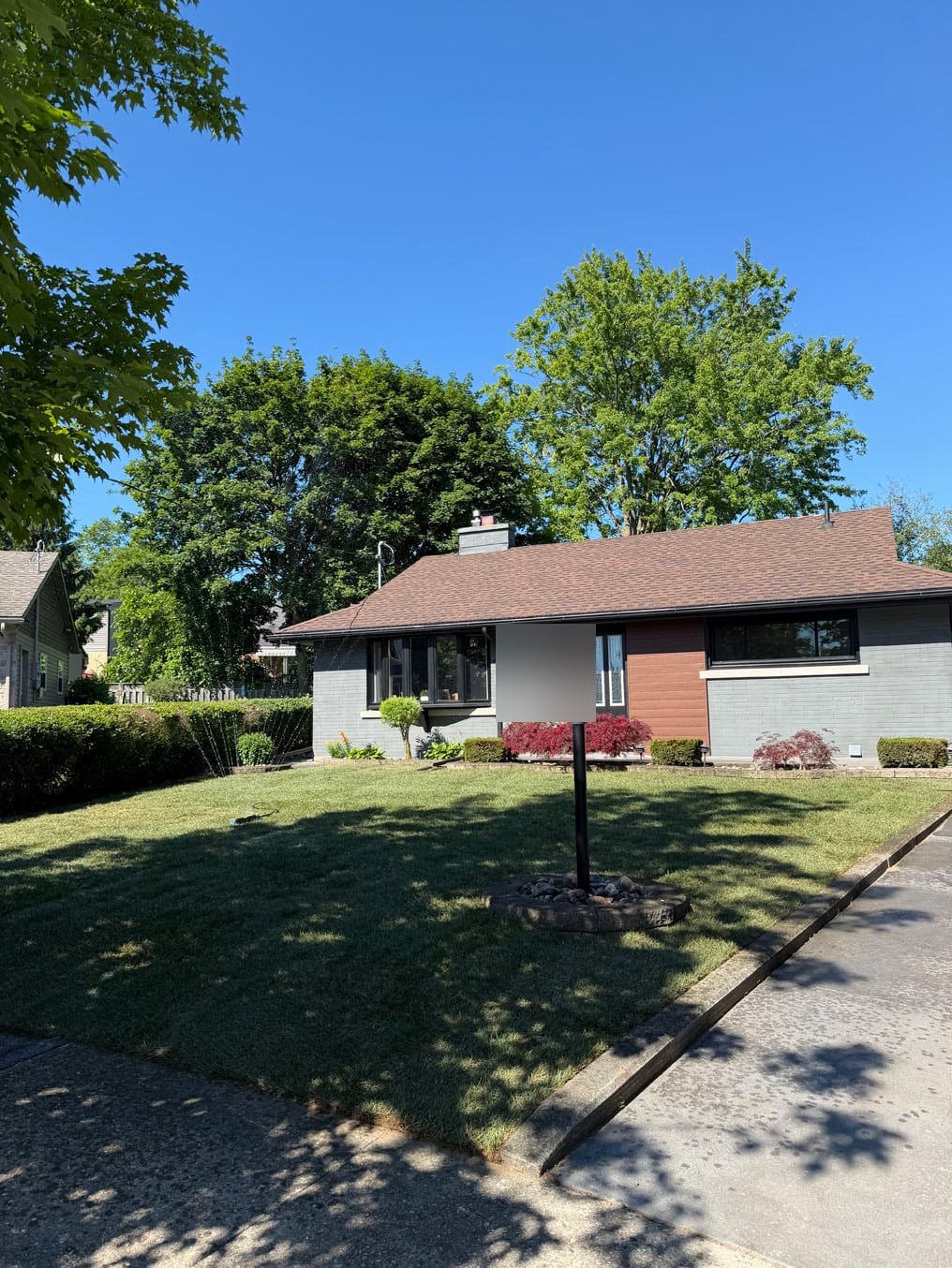 Finished Kentucky bluegrass sod front lawn around the lamp post at a grey brick bungalow in Fairfield, Kitchener