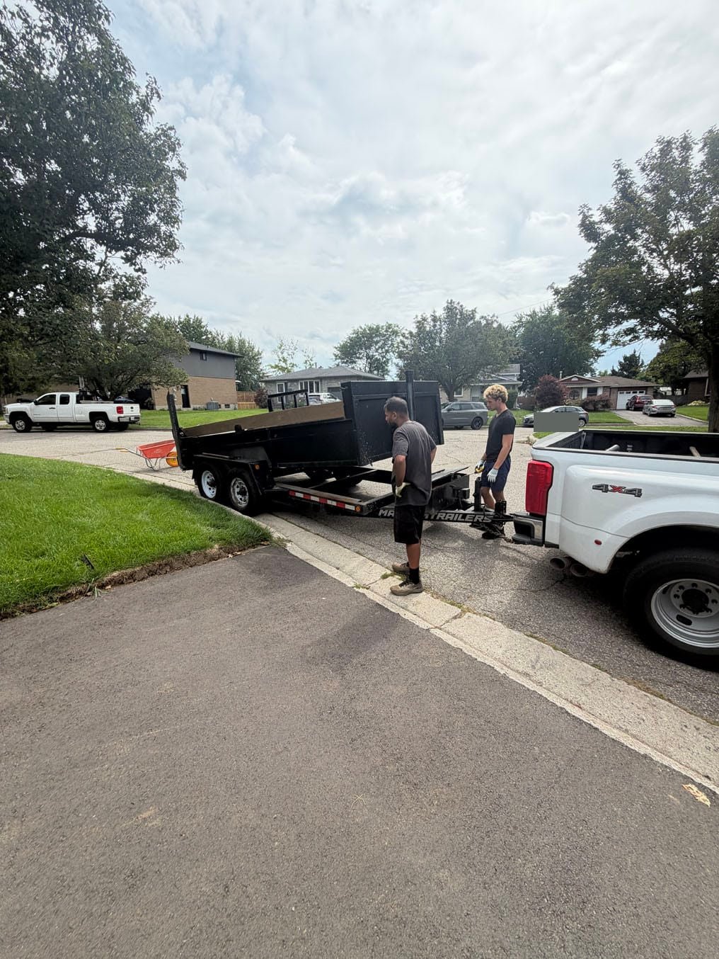 Crew loading old turf onto a dump trailer at the curb in Forest Heights, Kitchener