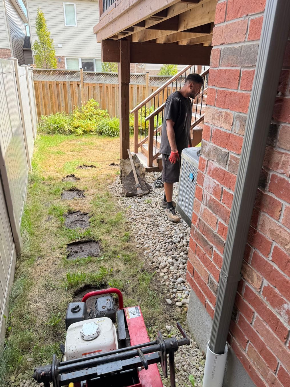 Sod Installation In Grand River South, Kitchener 2 Sod cutter at the side of the house with a crew member at the corner, Grand River South, Kitchener
