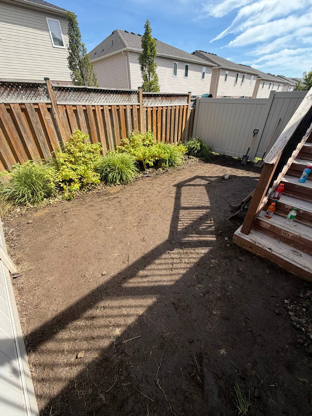 Sod Installation In Grand River South, Kitchener 3 Old turf out and fresh topsoil graded under the deck stairs in a Grand River South, Kitchener back yard