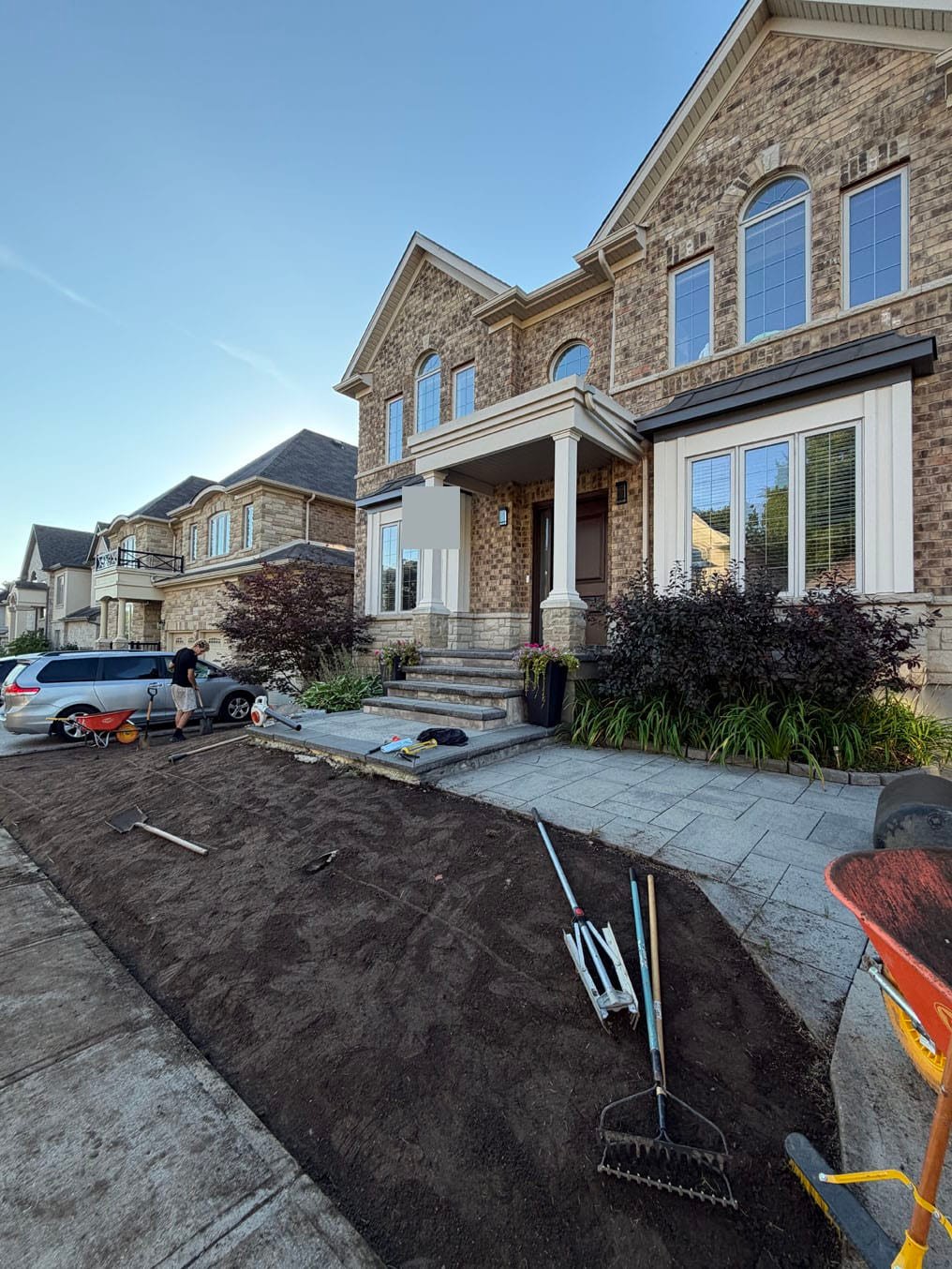 Front Lawn Sod Replacement In Grand River South, Kitchener 3 Fresh topsoil raked level between the walkway and the driveway, rakes on the bed, Grand River South, Kitchener