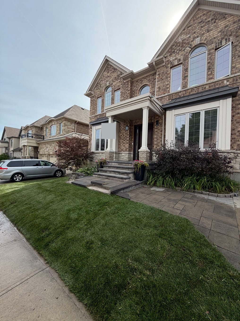 Finished Kentucky bluegrass sod front lawn between the walkway and the driveway at a brick home in Grand River South, Kitchener