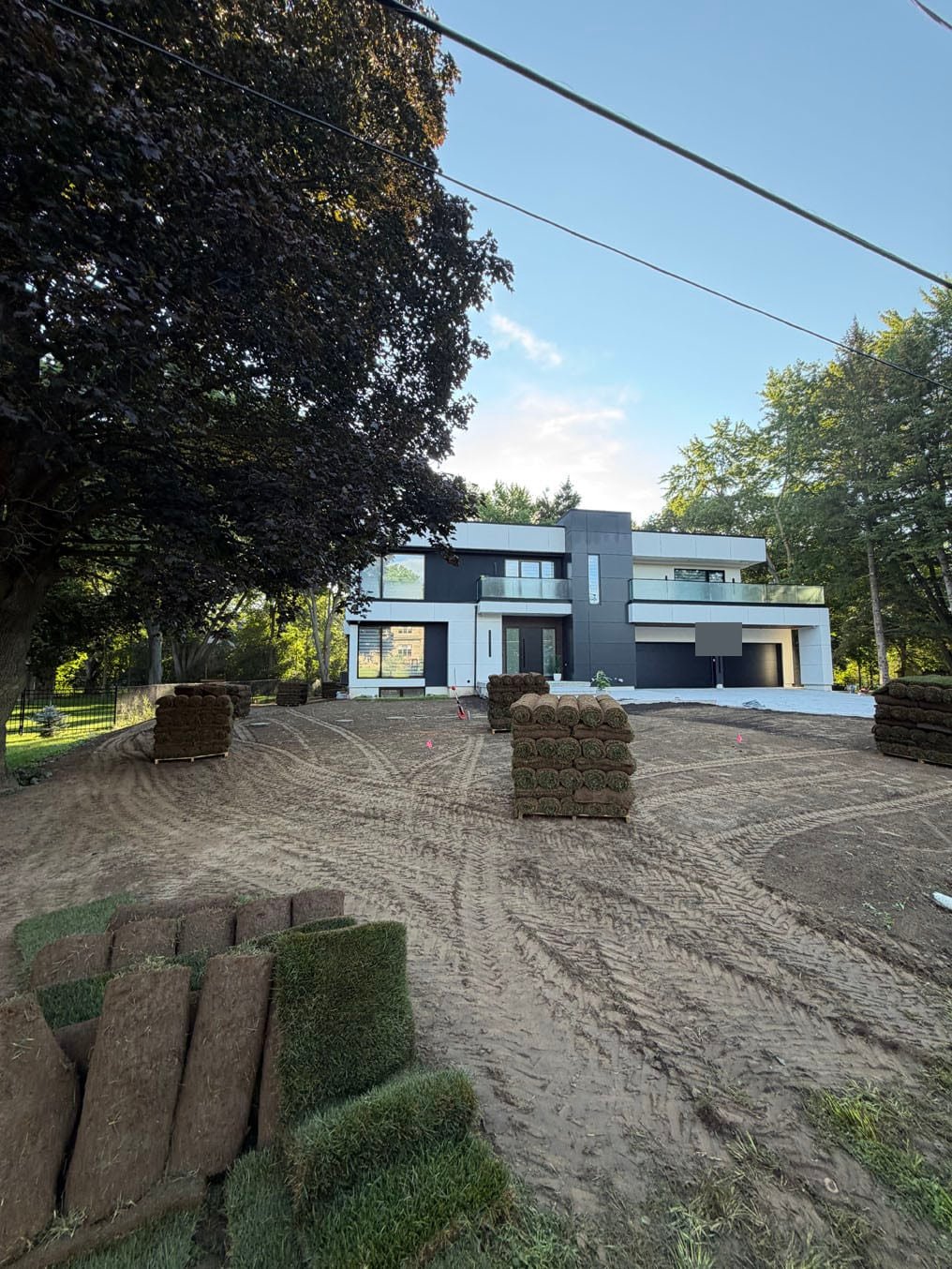 Sod Prices 2 Rolls and pallets of fresh Kentucky Bluegrass sod set out across a graded front yard in Waterloo