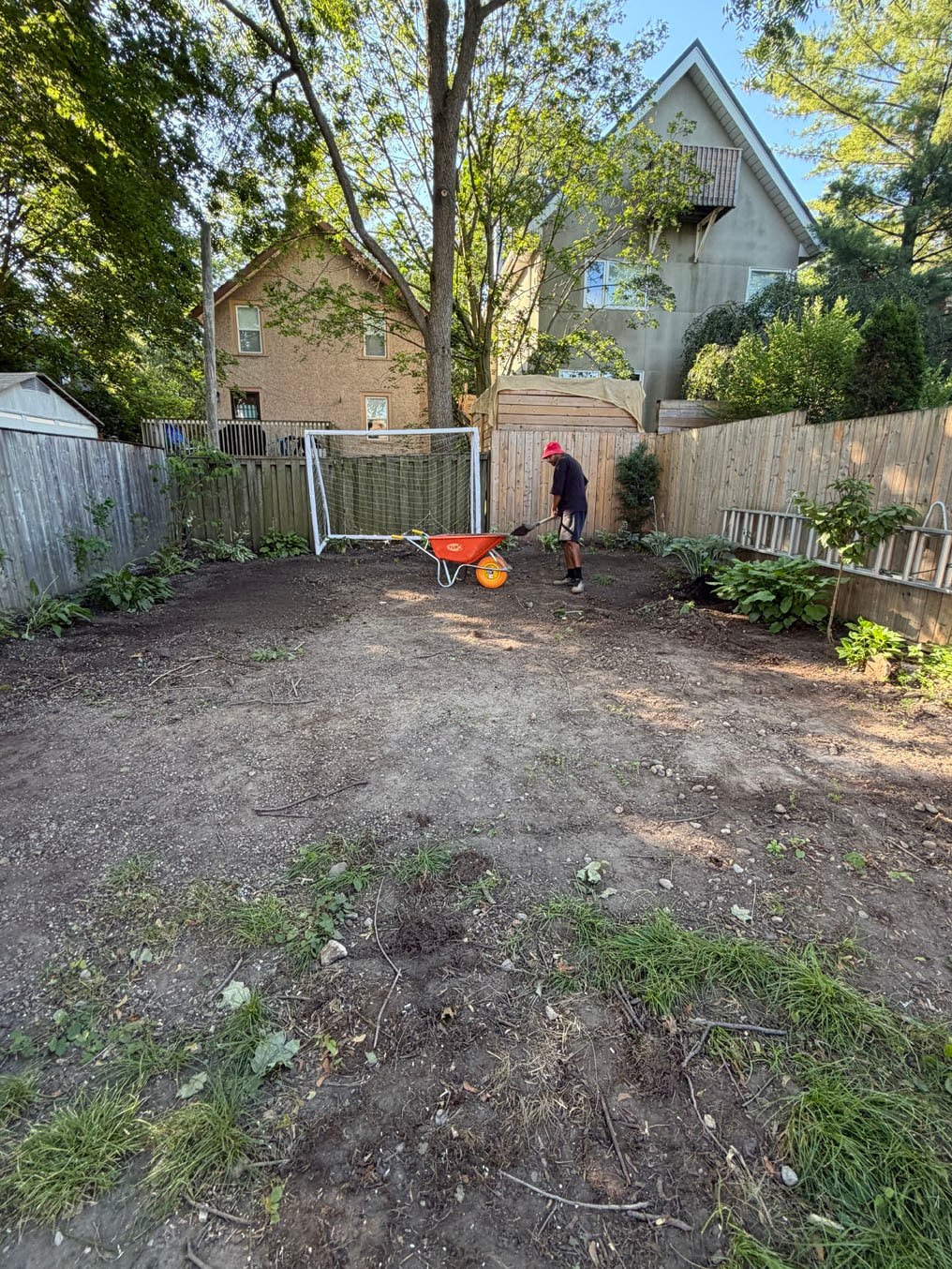 Back yard stripped of old turf, crew member at the soccer net, Old University, Guelph