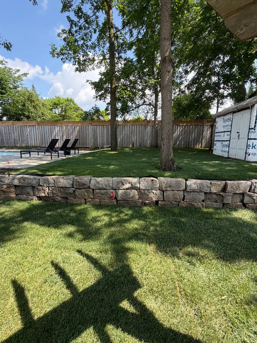 Sod Installation Pioneer Tower West 7 New sod on both levels of the Pioneer Tower West, Kitchener backyard, split by the stone retaining wall below the pool terrace
