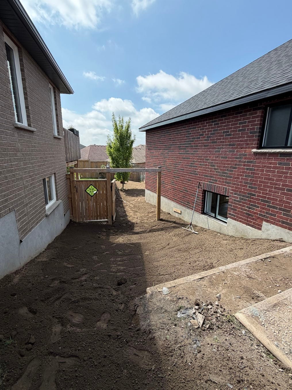 Back of the side yard raked and graded with fresh topsoil from the pad to the arbor, rake by the basement window, Plattsville, Ontario