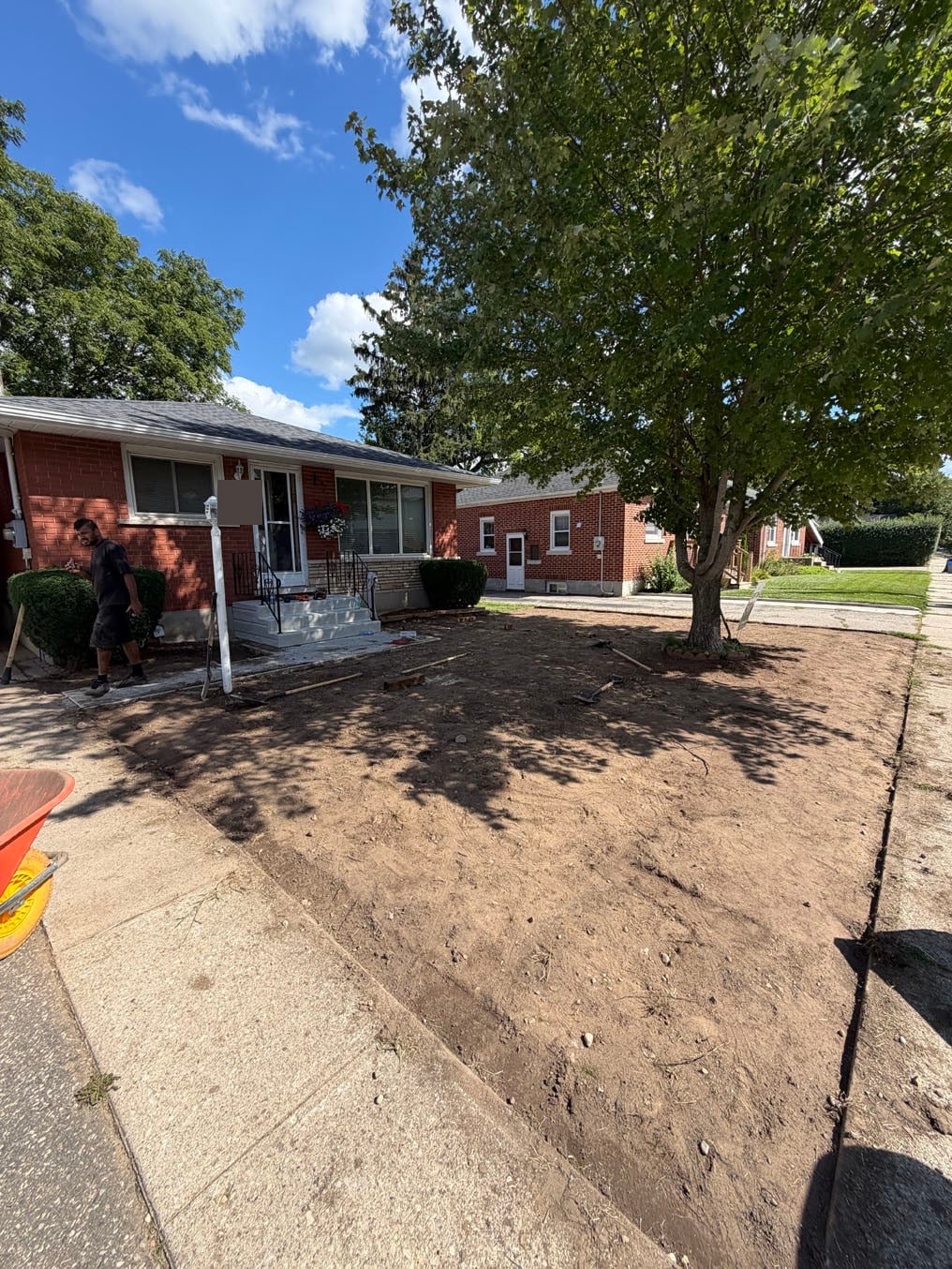 What Is Included in Sod Installation? 2 Front lawn in Preston, Cambridge stripped to bare soil and graded level from the porch to the sidewalk, ready for Kentucky bluegrass sod