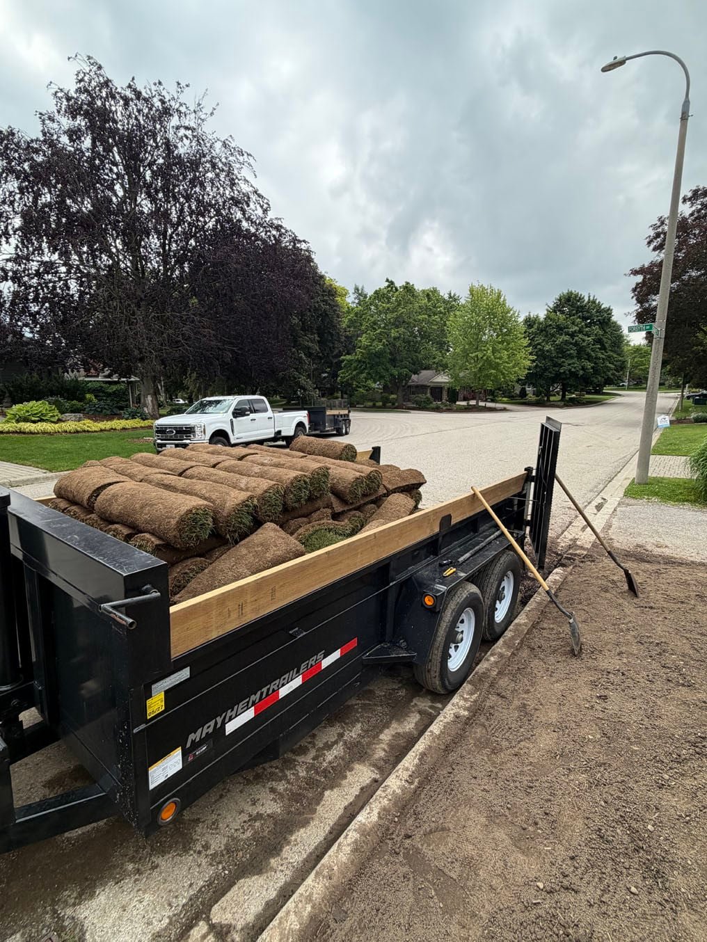 Sod Prices 1 A trailer load of sod rolls parked at the curb beside a graded front yard in Waterloo, ready to be laid