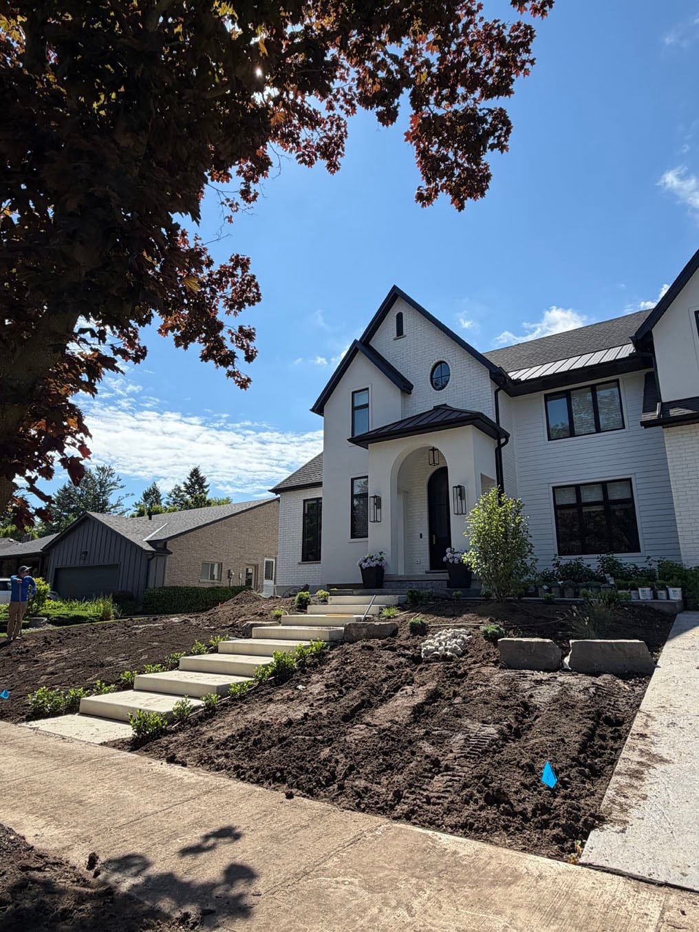 Front Lawn Sod Replacement In Westmount, Kitchener 3 Fresh topsoil graded either side of the stone steps at a white-brick home in Westmount, Kitchener, ready for sod